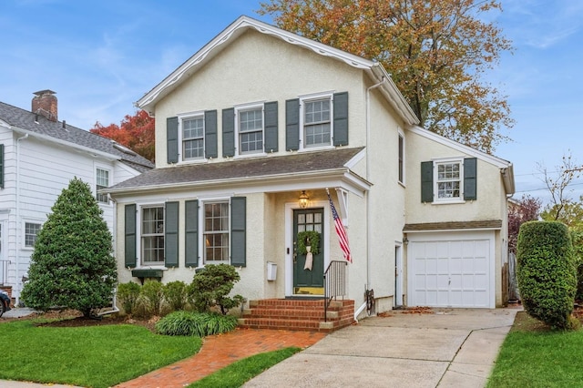 12 5th Pl, Garden City, NY 11530 - view of front facade featuring concrete driveway, stucco siding, and a garage