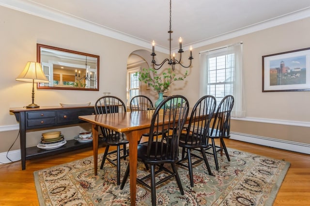 12 5th Pl, Garden City, NY 11530 - dining area with a chandelier, healthy amount of natural light, arched walkways, a baseboard radiator, and crown molding