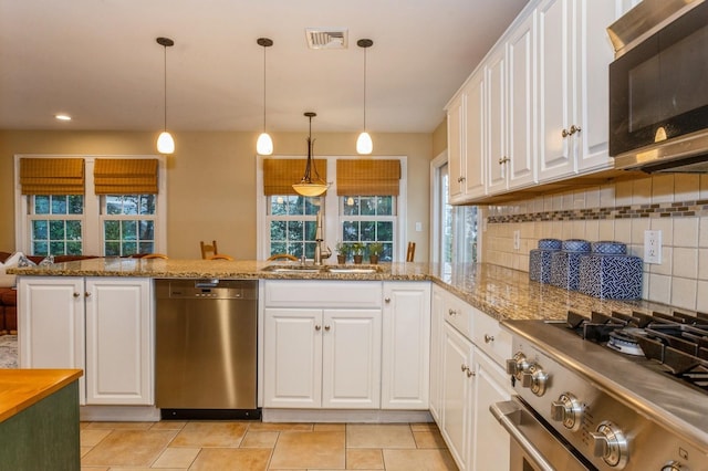 12 5th Pl, Garden City, NY 11530 - kitchen featuring stainless steel dishwasher, stove, a sink, white cabinetry, and tasteful backsplash