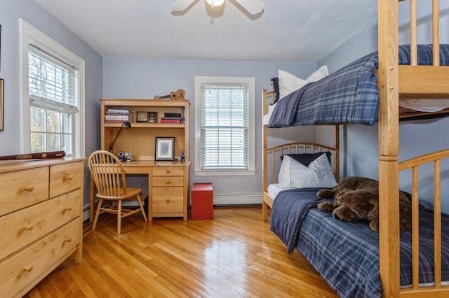 12 5th Pl, Garden City, NY 11530 - bedroom with light wood-style floors, baseboard heating, baseboards, ceiling fan, and an office area