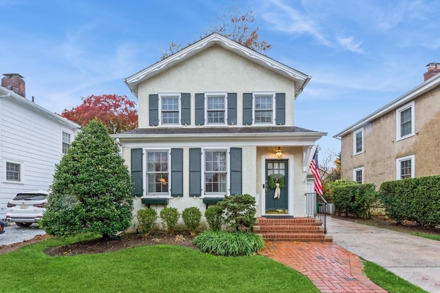 12 5th Pl, Garden City, NY 11530 - view of front facade featuring stucco siding and a front lawn