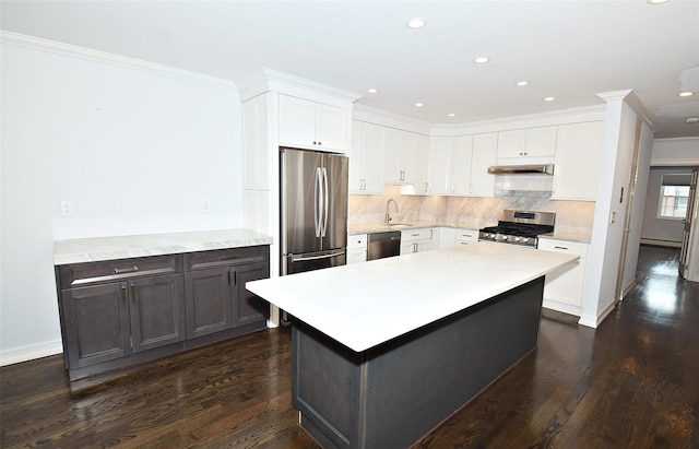 206-07 Lori Dr Unit 60M, Bayside, NY 11360 - kitchen featuring stainless steel appliances, under cabinet range hood, light countertops, dark wood-type flooring, and ornamental molding