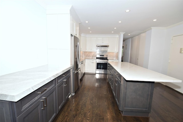 206-07 Lori Dr Unit 60M, Bayside, NY 11360 - kitchen featuring appliances with stainless steel finishes, white cabinetry, dark wood-style flooring, under cabinet range hood, and a center island
