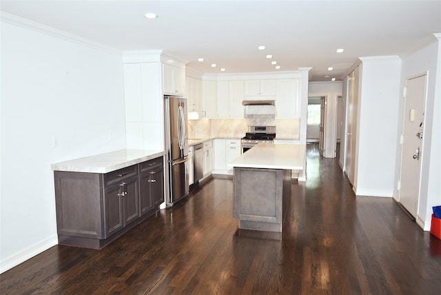 206-07 Lori Dr Unit 60M, Bayside, NY 11360 - kitchen with appliances with stainless steel finishes, light countertops, dark wood-style floors, white cabinets, and crown molding