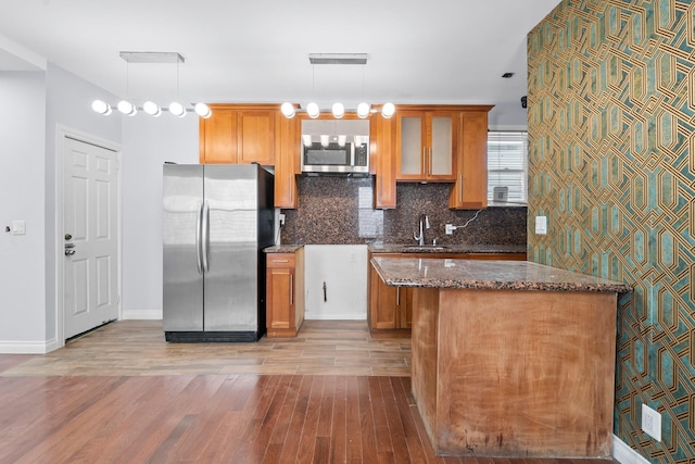 114-23 Sutter Ave, South Ozone Park, NY 11420 - kitchen with stainless steel appliances, light wood-style floors, dark stone counters, and tasteful backsplash