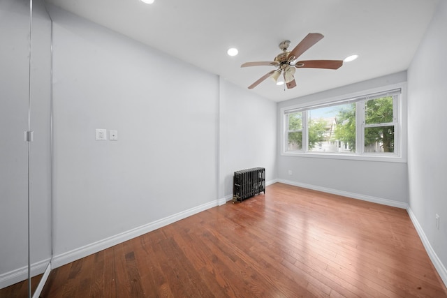 114-23 Sutter Ave, South Ozone Park, NY 11420 - unfurnished living room featuring wood finished floors, ceiling fan, baseboards, recessed lighting, and radiator