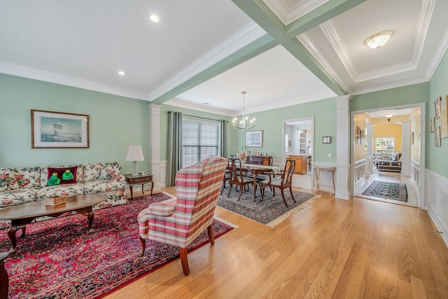105 Louden Loop, Mount Sinai, NY 11766 - living area featuring a chandelier, light wood finished floors, ornamental molding, a wainscoted wall, and a decorative wall