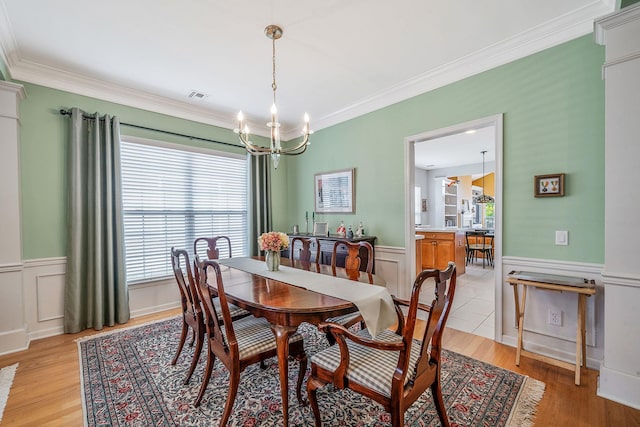 105 Louden Loop, Mount Sinai, NY 11766 - dining area with crown molding, a chandelier, wainscoting, and light wood-style floors