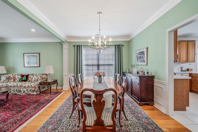 105 Louden Loop, Mount Sinai, NY 11766 - dining room featuring a chandelier, crown molding, light wood-style flooring, and wainscoting