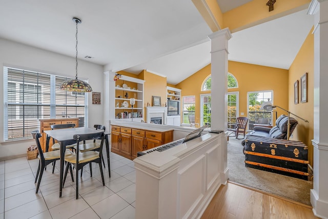 105 Louden Loop, Mount Sinai, NY 11766 - kitchen featuring a peninsula, brown cabinets, ornate columns, decorative light fixtures, and open floor plan