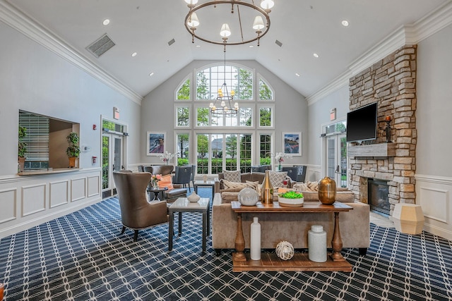 105 Louden Loop, Mount Sinai, NY 11766 - carpeted living room featuring a chandelier, a wainscoted wall, a stone fireplace, high vaulted ceiling, and a decorative wall