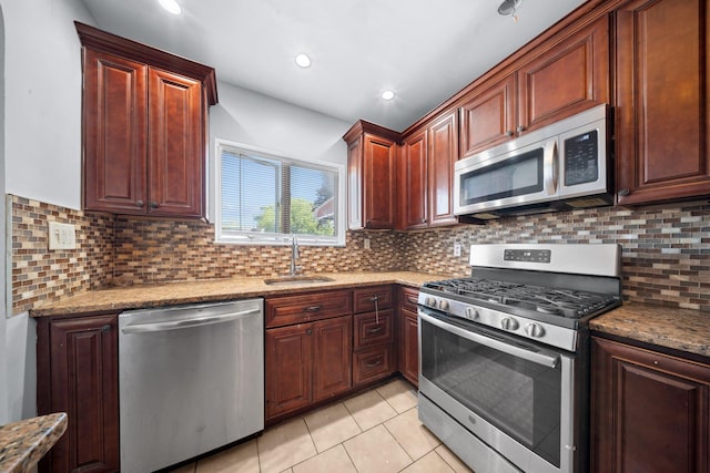 1549 E 57th St, Brooklyn, NY 11234 - kitchen with appliances with stainless steel finishes, a sink, light tile patterned floors, backsplash, and light stone countertops