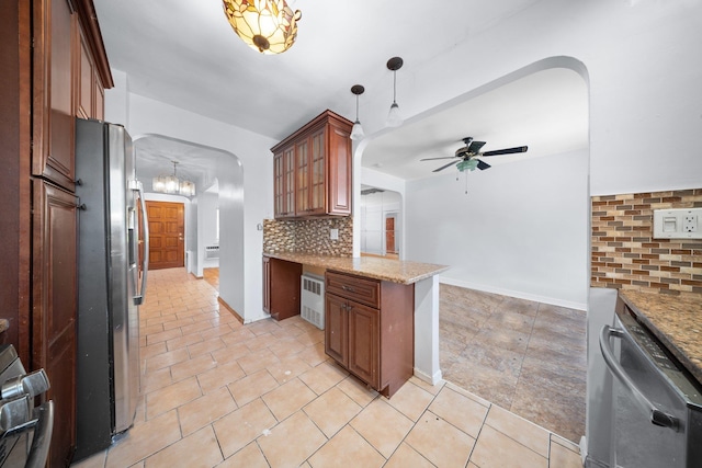 1549 E 57th St, Brooklyn, NY 11234 - kitchen featuring appliances with stainless steel finishes, ceiling fan, backsplash, arched walkways, and light stone countertops