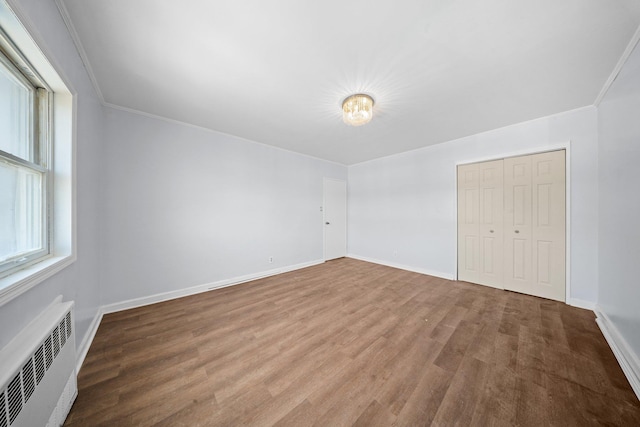 1549 E 57th St, Brooklyn, NY 11234 - unfurnished bedroom with baseboards, wood finished floors, ornamental molding, a closet, and radiator heating unit