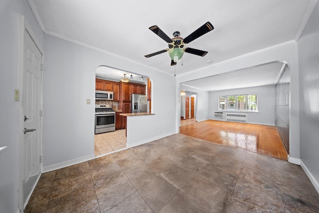 1549 E 57th St, Brooklyn, NY 11234 - unfurnished living room featuring arched walkways, baseboards, ceiling fan, ornamental molding, and radiator heating unit
