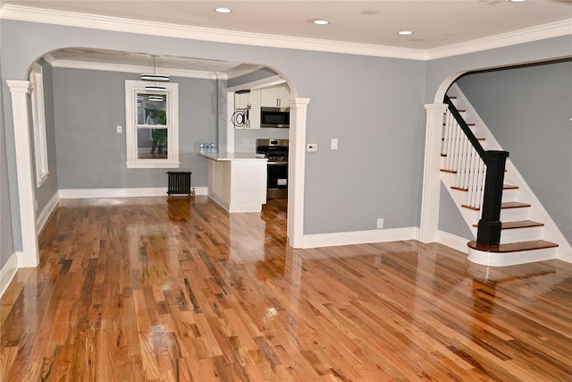200-13 116th Ave, Saint Albans, NY 11412 - spare room featuring arched walkways, light wood finished floors, stairs, baseboards, and ornamental molding