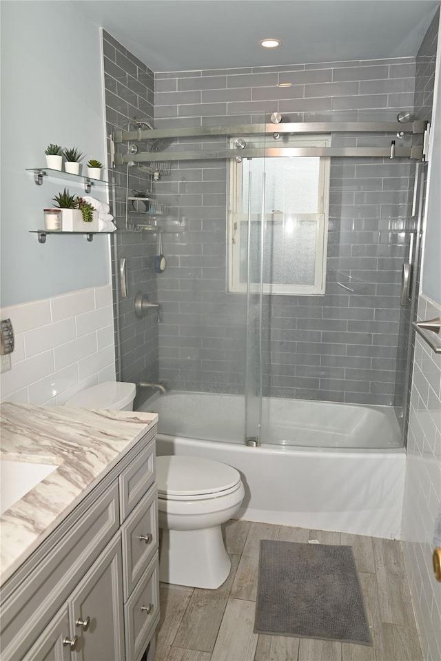 1510 Rica Pl, Valley Stream, NY 11580 - full bath with vanity, toilet, tile walls, combined bath / shower with glass door, and wood finish floors