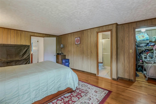 20 Baylis Pl, Syosset, NY 11791 - bedroom with wood walls, wood finished floors, a walk in closet, a closet, and ornamental molding