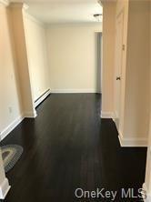 49 Tanager Rd Unit 4905, Monroe, NY 10950 - hall with baseboard heating, crown molding, baseboards, and dark wood-style flooring