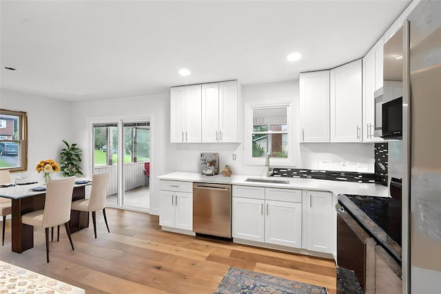83 Scott Dr, Wappingers Falls, NY 12590 - kitchen featuring dishwasher, black range with electric cooktop, white cabinetry, light wood-type flooring, and recessed lighting