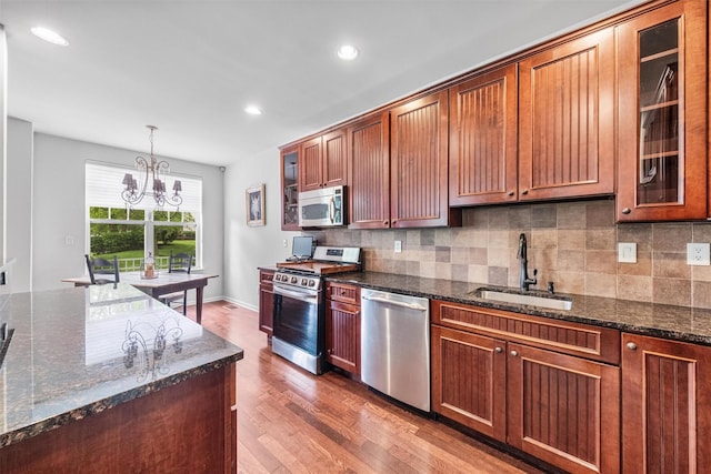 1 Country Club Dr, Middletown, NY 10940 - kitchen with stainless steel appliances, a sink, wood finished floors, a chandelier, and decorative backsplash