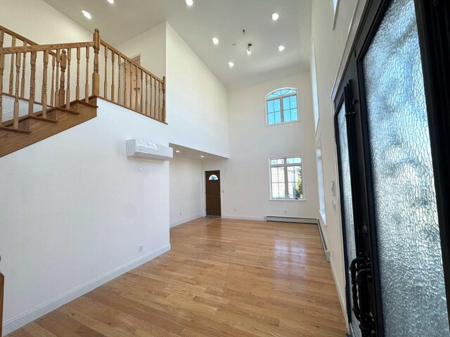 36-46 205th St, Bayside, NY 11361 - entrance foyer with light wood-type flooring, a high ceiling, a baseboard heating unit, recessed lighting, and stairs
