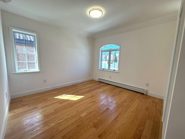 36-46 205th St, Bayside, NY 11361 - spare room with a baseboard radiator, light wood-type flooring, and baseboards