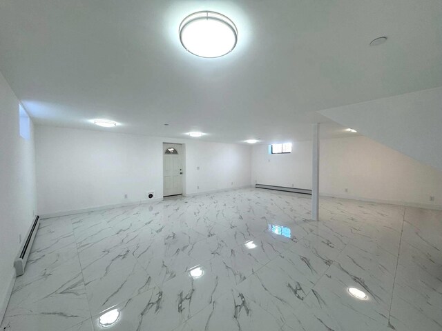 36-46 205th St, Bayside, NY 11361 - below grade area with baseboard heating, a baseboard heating unit, baseboards, and light marble finish floors