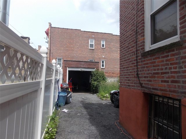 1777 Edenwald Ave, Bronx, NY 10466 - view of side of property featuring brick siding, an attached garage, and asphalt driveway