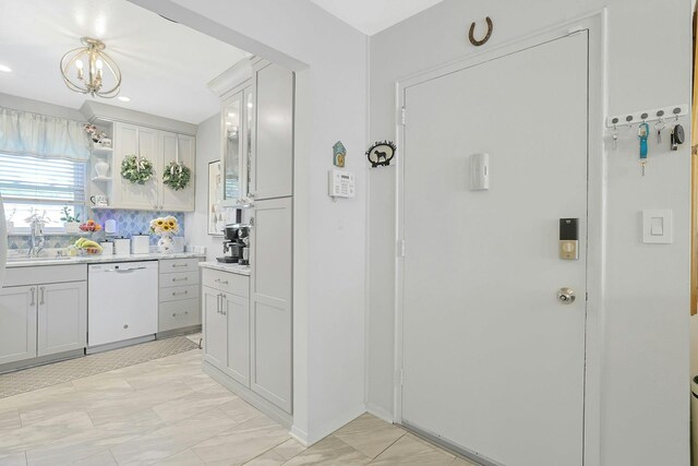 135-5 S Highland Ave Unit D4, Ossining, NY 10562 - kitchen featuring white dishwasher, light countertops, decorative backsplash, a chandelier, and a sink