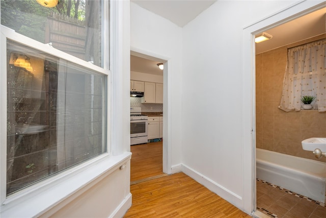 3496 Fort Independence St, Bronx, NY 10463 - bathroom with decorative backsplash, wood finished floors, and baseboards