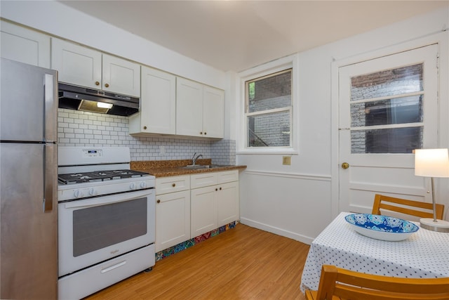 3496 Fort Independence St, Bronx, NY 10463 - kitchen featuring under cabinet range hood, white gas range oven, freestanding refrigerator, light wood-style floors, and tasteful backsplash