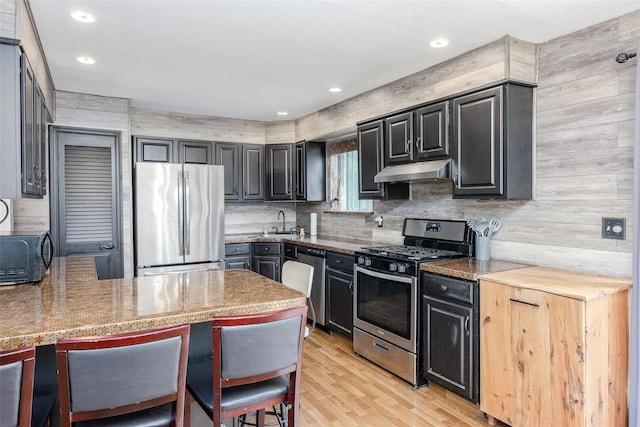 112 Middle Island Blvd, Middle Island, NY 11953 - kitchen with stainless steel appliances, under cabinet range hood, light wood finished floors, dark cabinetry, and recessed lighting