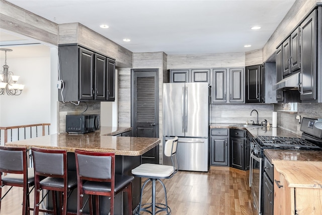 112 Middle Island Blvd, Middle Island, NY 11953 - kitchen featuring range with gas cooktop, freestanding refrigerator, black microwave, a peninsula, and light wood-style flooring