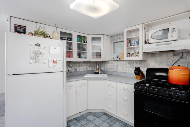 112 Middle Island Blvd, Middle Island, NY 11953 - kitchen featuring white appliances, under cabinet range hood, light countertops, light tile patterned floors, and decorative backsplash
