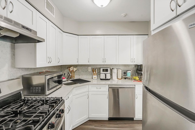 120 Fairview Cir Unit 120, Middle Island, NY 11953 - kitchen featuring stainless steel appliances, under cabinet range hood, light countertops, and white cabinets
