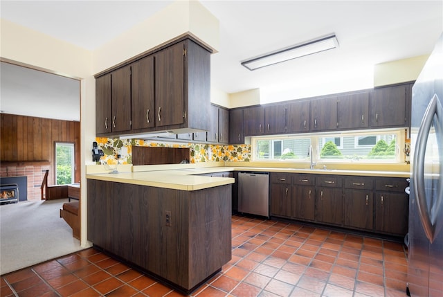 6 Bay View Dr, Hampton Bays, NY 11946 - kitchen featuring appliances with stainless steel finishes, dark brown cabinets, a peninsula, and a sink