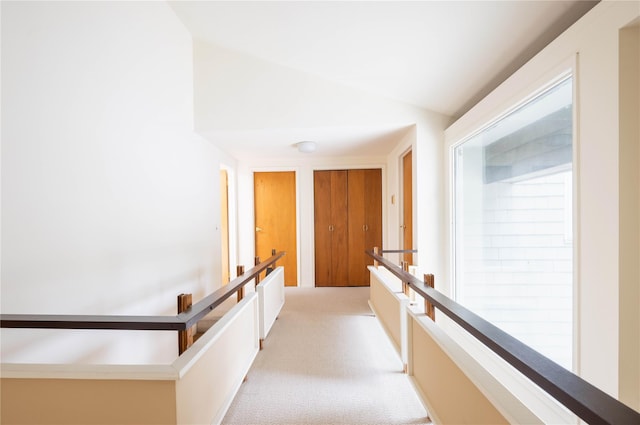 6 Bay View Dr, Hampton Bays, NY 11946 - corridor with light colored carpet, vaulted ceiling, and an upstairs landing