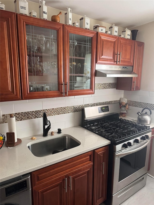 233-06 131st St Unit 1, Rosedale, NY 11412 - kitchen featuring stainless steel gas stove, under cabinet range hood, a sink, tasteful backsplash, and glass insert cabinets