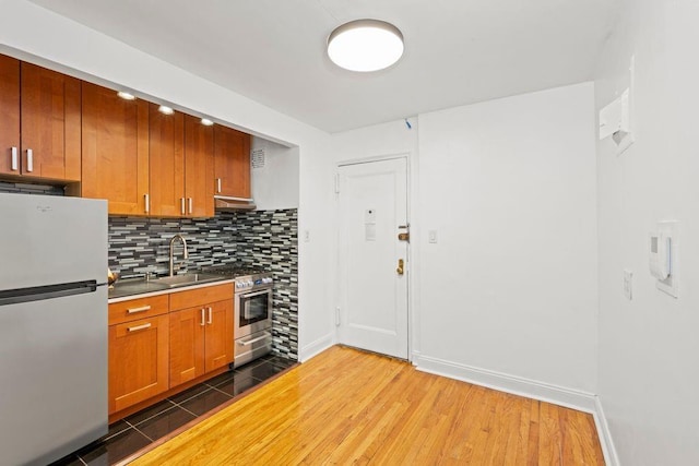 15 Oliver St Unit 3C, Brooklyn, NY 11209 - kitchen with appliances with stainless steel finishes, a sink, tasteful backsplash, light wood-style flooring, and baseboards