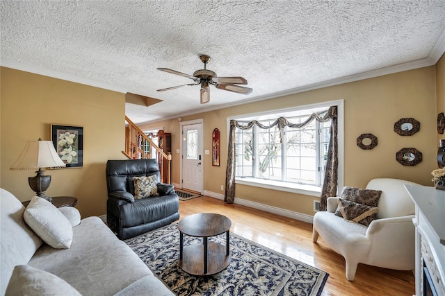 2193 Post St, East Meadow, NY 11554 - living room with crown molding, a textured ceiling, ceiling fan, light wood finished floors, and stairs