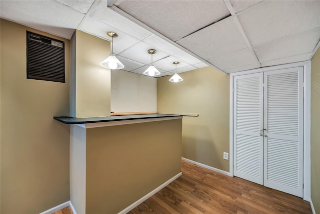 2193 Post St, East Meadow, NY 11554 - bar featuring wood finished floors, baseboards, a drop ceiling, and hanging light fixtures