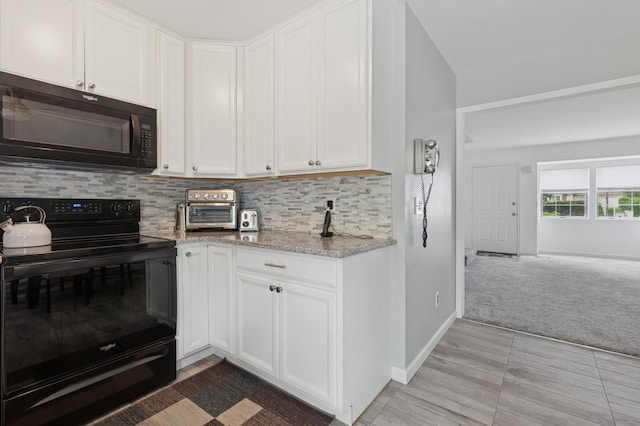 18 Taylor Commons, Yaphank, NY 11980 - kitchen featuring black appliances, tasteful backsplash, light stone countertops, and white cabinetry