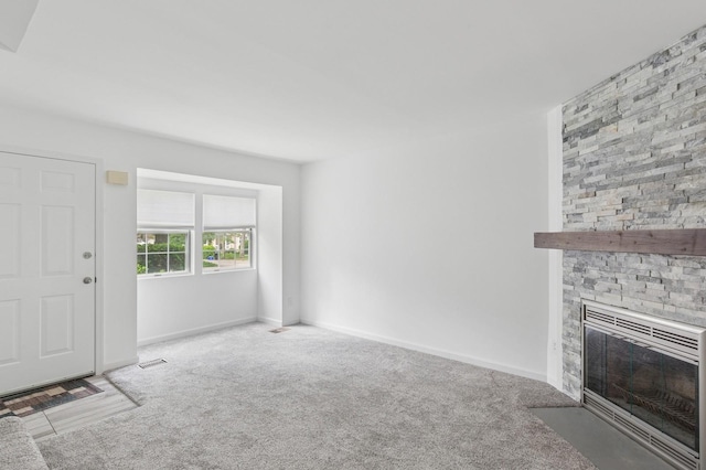 18 Taylor Commons, Yaphank, NY 11980 - unfurnished living room featuring a stone fireplace, carpet flooring, and baseboards