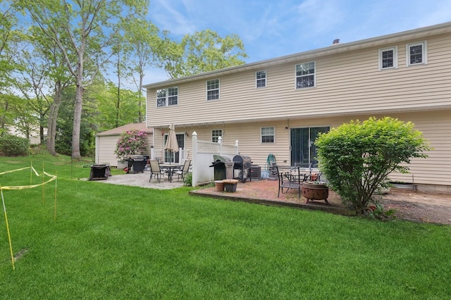 18 Taylor Commons, Yaphank, NY 11980 - rear view of house with a patio, a yard, and an outdoor fire pit
