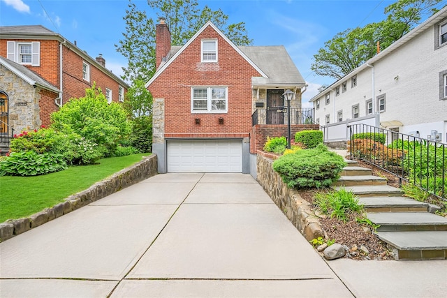 86-32 Avon St, Jamaica Estates, NY 11432 - view of front of property with an attached garage, brick siding, driveway, a chimney, and stairway