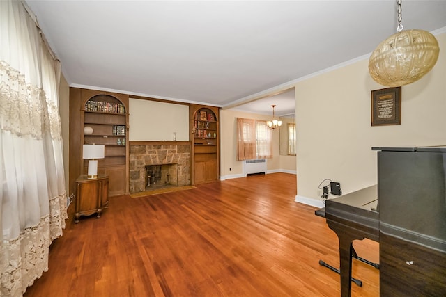 86-32 Avon St, Jamaica Estates, NY 11432 - unfurnished living room with radiator heating unit, wood finished floors, a chandelier, baseboards, and ornamental molding