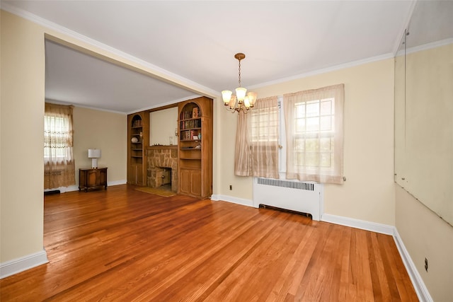 86-32 Avon St, Jamaica Estates, NY 11432 - unfurnished living room featuring radiator, a chandelier, wood finished floors, a stone fireplace, and baseboards