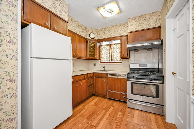 86-32 Avon St, Jamaica Estates, NY 11432 - kitchen with freestanding refrigerator, stainless steel range with gas stovetop, wallpapered walls, range hood, and dishwasher