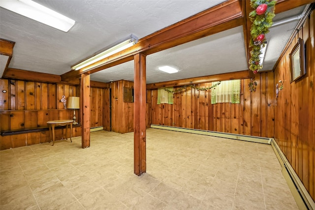86-32 Avon St, Jamaica Estates, NY 11432 - finished below grade area with a baseboard radiator, wooden walls, baseboard heating, and a textured ceiling